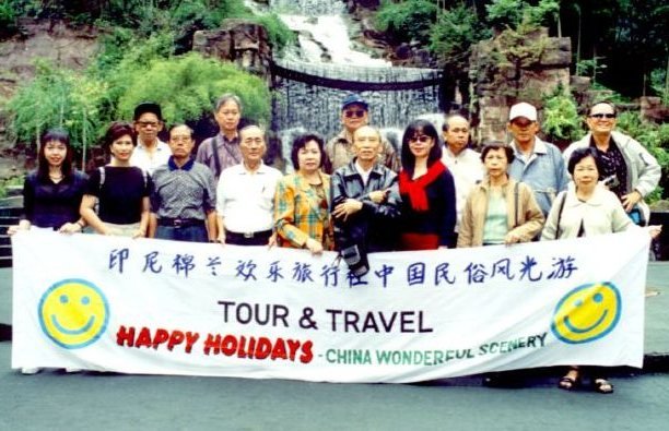 Rombongan Happy Holidays di depan air terjun pada perjalanan China Wonderful Scenery