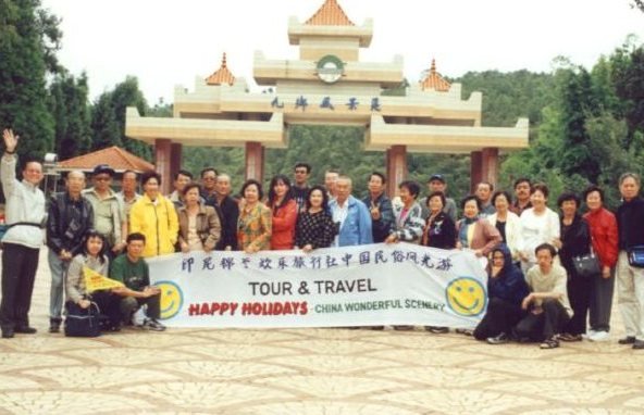 Rombongan Happy Holidays di depan gerbang taman wisata bergaya klasik, Tiongkok