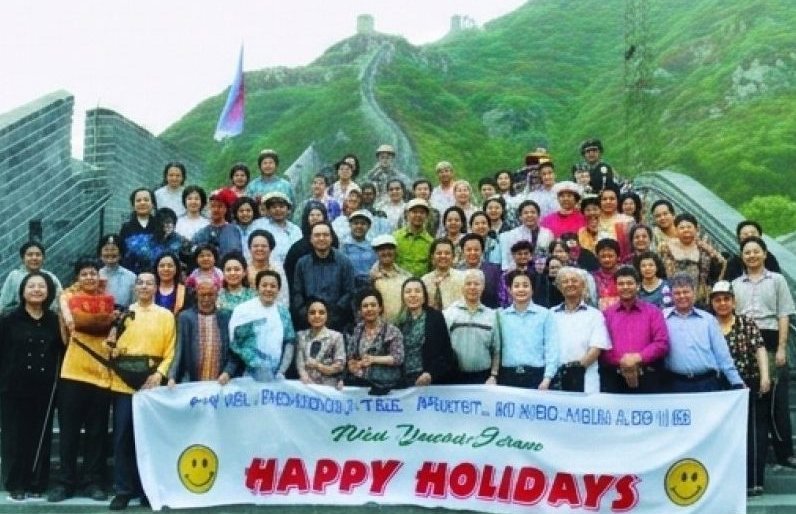 Rombongan besar Happy Holidays membentang spanduk di anak tangga Tembok Besar, Tiongkok