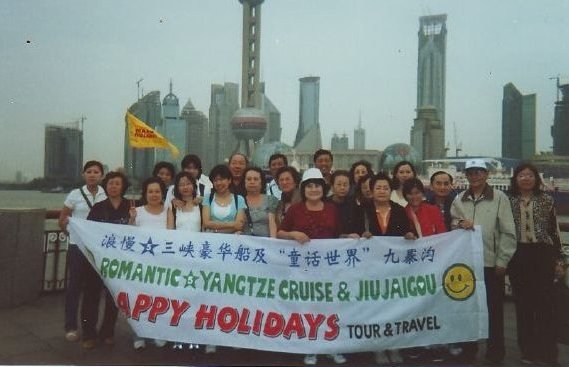 Rombongan Happy Holidays di tepi Sungai Huangpu dengan latar Menara Oriental Pearl, Shanghai